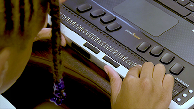 Student using a refreshable Braille display